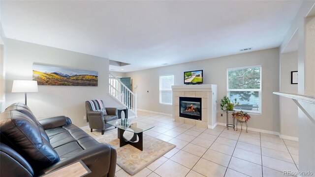 7270 Marmot Ridge Pl, Littleton, CO 80125 - living room with stairway, light tile patterned flooring, plenty of natural light, and a tiled fireplace