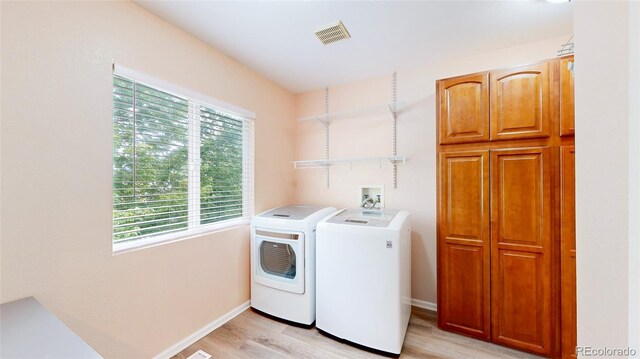7270 Marmot Ridge Pl, Littleton, CO 80125 - washroom featuring washing machine and clothes dryer, light wood-style floors, and cabinet space