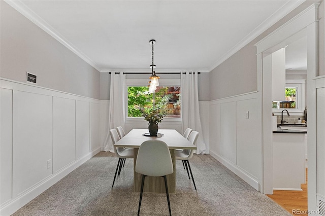 8132 Lodgepole Trl, Lone Tree, CO 80124 - dining area with a decorative wall, ornamental molding, wainscoting, and light colored carpet