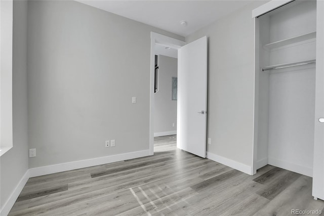 unfurnished bedroom with light hardwood / wood-style floors and a closet