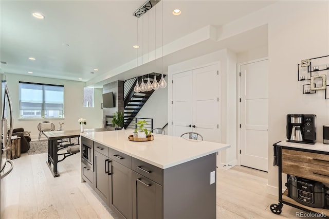 4100 E Iliff Ave Unit 4, Denver, CO 80222 - kitchen featuring light wood finished floors, open floor plan, gray cabinetry, light countertops, and recessed lighting