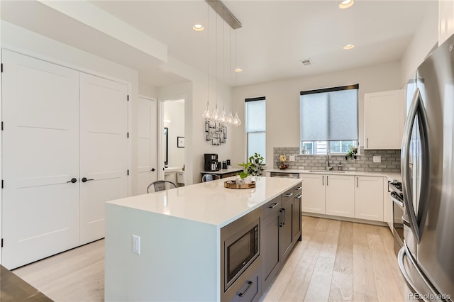 4100 E Iliff Ave Unit 4, Denver, CO 80222 - kitchen with stainless steel appliances, a sink, light wood-style flooring, light countertops, and recessed lighting