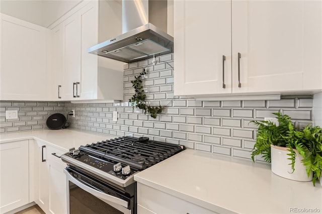 4100 E Iliff Ave Unit 4, Denver, CO 80222 - kitchen featuring stainless steel gas range oven, wall chimney range hood, white cabinetry, light countertops, and decorative backsplash