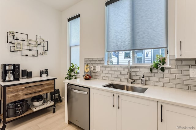 4100 E Iliff Ave Unit 4, Denver, CO 80222 - kitchen featuring stainless steel dishwasher, a sink, decorative backsplash, white cabinetry, and light wood finished floors