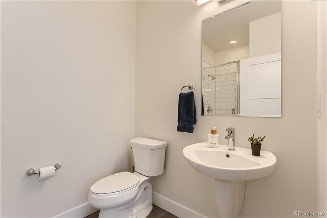 4100 E Iliff Ave Unit 4, Denver, CO 80222 - bathroom featuring baseboards, toilet, a shower, and a sink