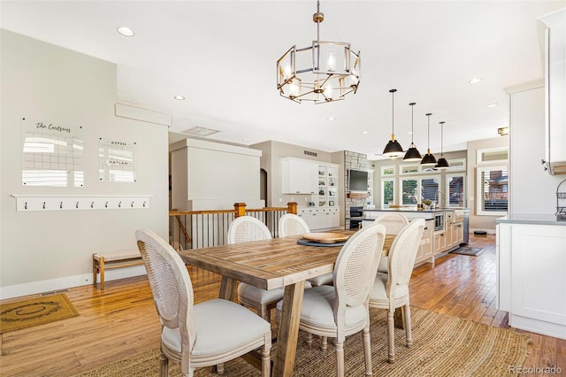 dining space featuring a chandelier, light hardwood / wood-style flooring, and a wealth of natural light