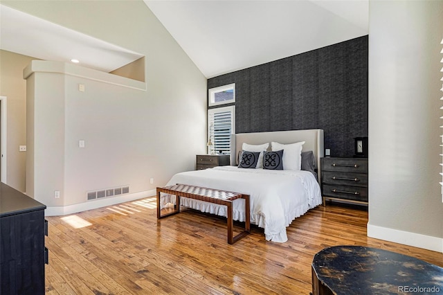 bedroom featuring hardwood / wood-style floors and high vaulted ceiling