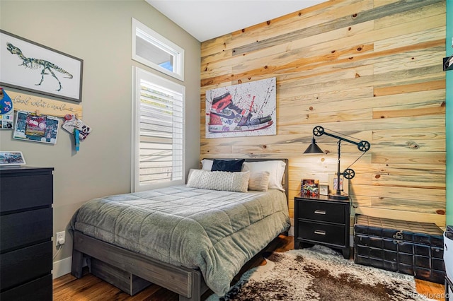 bedroom with wood walls and hardwood / wood-style floors