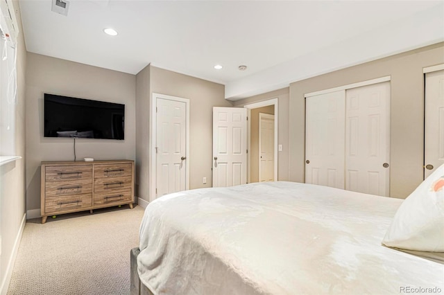 carpeted bedroom featuring two closets