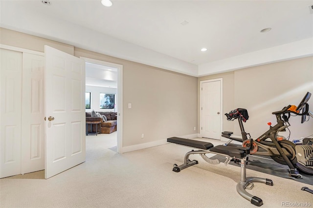 workout room featuring light carpet