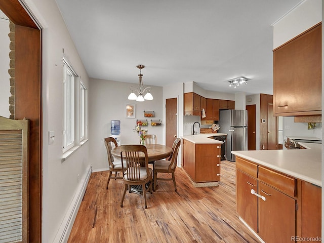 461 Nome St, Aurora, CO 80010 - dining space featuring a baseboard radiator, light wood finished floors, a chandelier, and baseboards