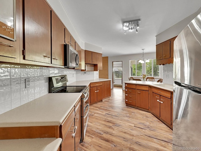 461 Nome St, Aurora, CO 80010 - kitchen with stainless steel appliances, a chandelier, light wood finished floors, and light countertops