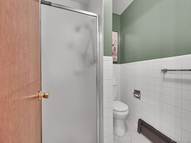 461 Nome St, Aurora, CO 80010 - bathroom with a shower stall, tile walls, toilet, wainscoting, and tile patterned floors