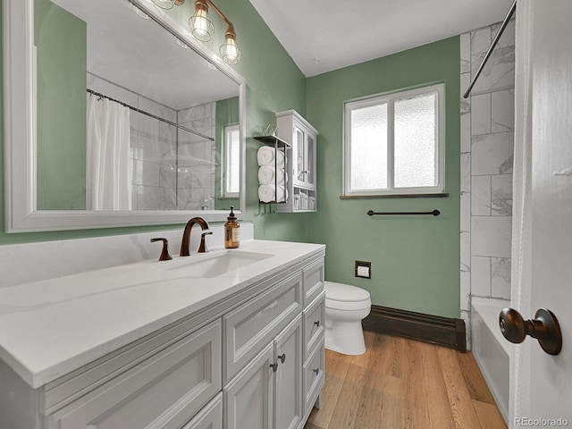 461 Nome St, Aurora, CO 80010 - full bathroom featuring toilet, wood finished floors, vanity, and shower / bath combo with shower curtain