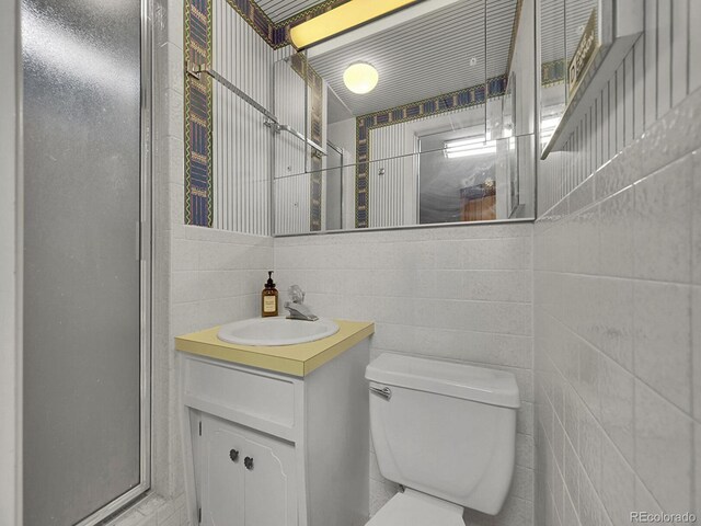 461 Nome St, Aurora, CO 80010 - bathroom featuring vanity, toilet, and tile walls