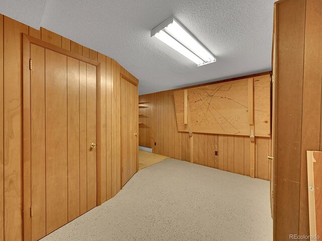 461 Nome St, Aurora, CO 80010 - finished below grade area featuring wood walls, a textured ceiling, and a baseboard radiator