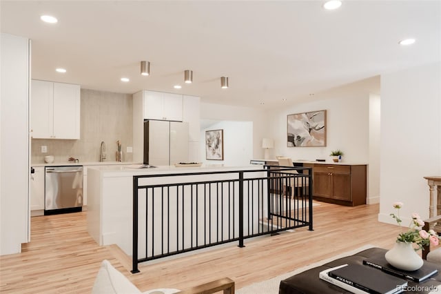 2257 S Lowell Blvd, Denver, CO 80219 - kitchen featuring stainless steel dishwasher, freestanding refrigerator, light countertops, light wood-style flooring, and a kitchen island