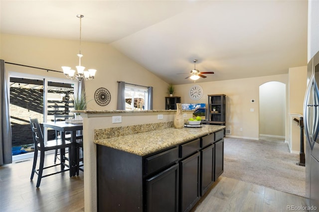 kitchen featuring pendant lighting, a healthy amount of sunlight, vaulted ceiling, and light wood-type flooring