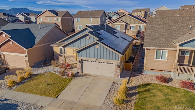 craftsman-style home featuring a mountain view, a front yard, and solar panels