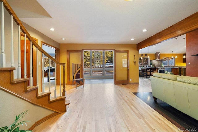 living area featuring stairs, recessed lighting, beam ceiling, and wood finished floors