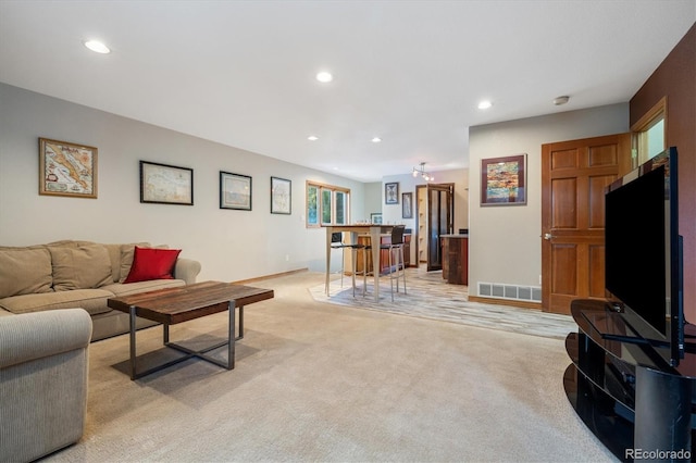 living area with visible vents, light colored carpet, and recessed lighting