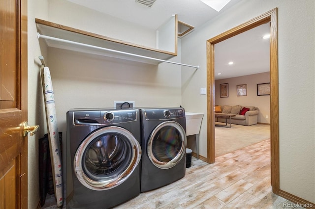 washroom with recessed lighting, laundry area, baseboards, light wood-type flooring, and washing machine and clothes dryer