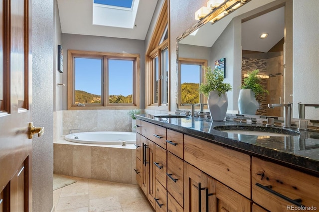 bathroom featuring a garden tub, double vanity, tiled shower, and a sink