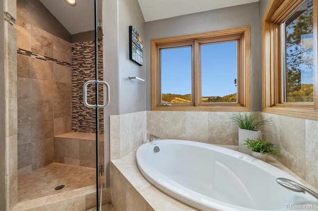 bathroom featuring vaulted ceiling, a shower stall, and a bath