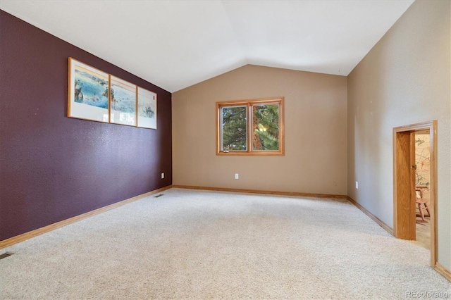 unfurnished room featuring light carpet, vaulted ceiling, visible vents, and baseboards