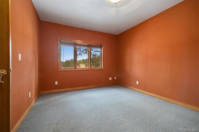 unfurnished room with carpet flooring and baseboards