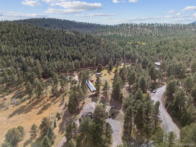 drone / aerial view with a wooded view