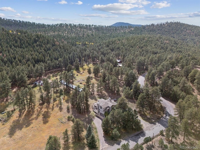 birds eye view of property featuring a mountain view and a view of trees