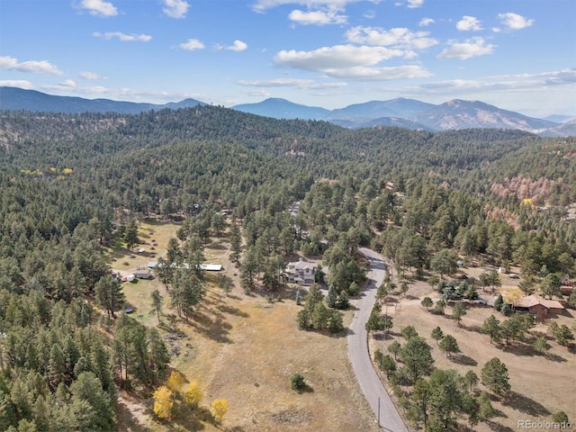 drone / aerial view featuring a mountain view and a view of trees