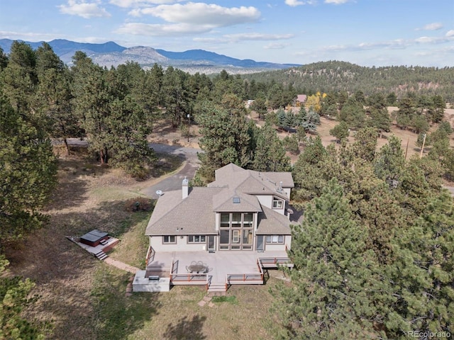 birds eye view of property featuring a mountain view and a view of trees