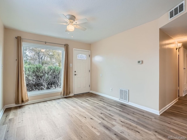 interior space featuring a textured ceiling, light hardwood / wood-style floors, and ceiling fan