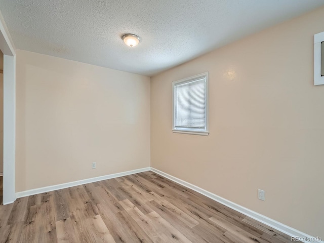 unfurnished room with a textured ceiling and light hardwood / wood-style flooring