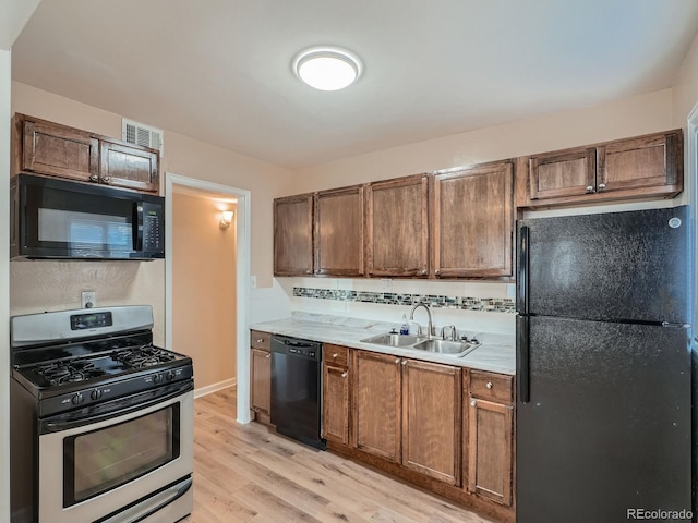 kitchen featuring sink, light wood-type flooring, and black appliances