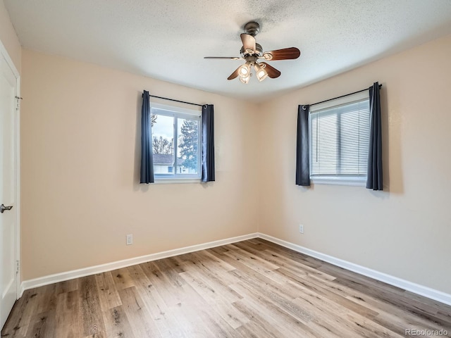 spare room featuring a textured ceiling, light hardwood / wood-style flooring, and ceiling fan