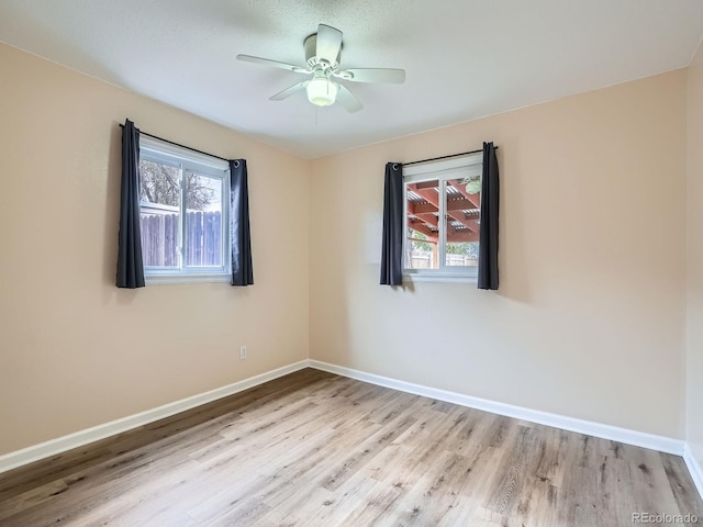 spare room with ceiling fan, light hardwood / wood-style flooring, and a textured ceiling