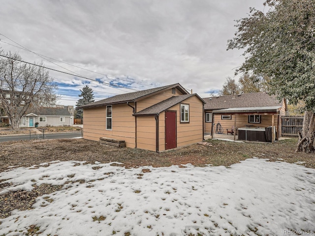 view of snowy exterior featuring central AC and a jacuzzi