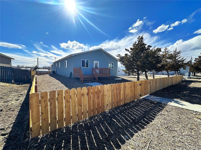 view of property exterior featuring fence private yard and a deck