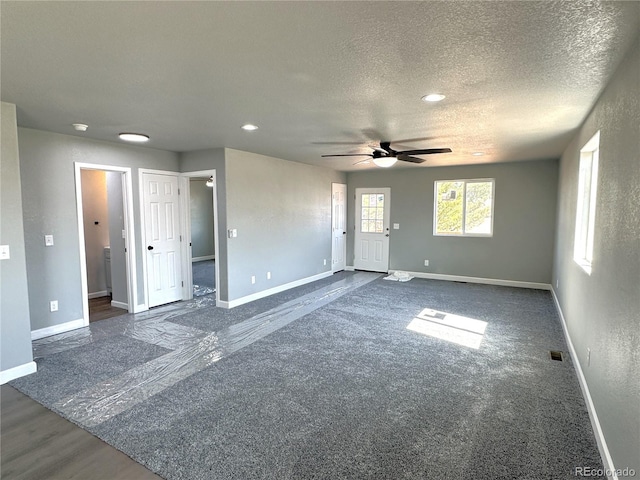 unfurnished room with ceiling fan, baseboards, and a textured ceiling