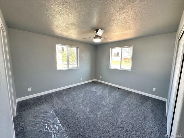 unfurnished bedroom featuring multiple windows, baseboards, and dark colored carpet