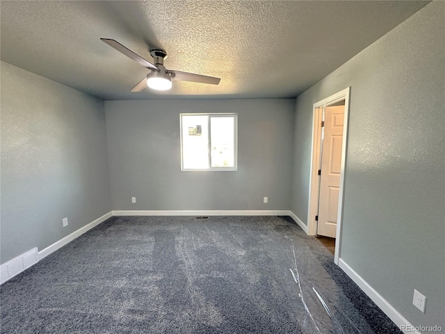 unfurnished room featuring ceiling fan, baseboards, dark colored carpet, and a textured ceiling