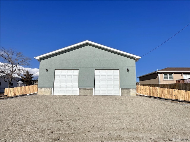 detached garage featuring fence