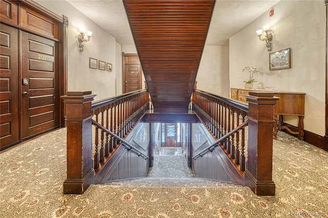 stairway with wood ceiling and carpet