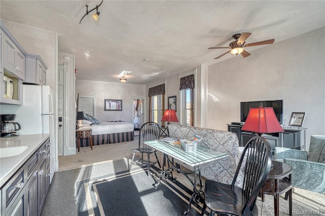 bedroom with sink, light colored carpet, and ceiling fan