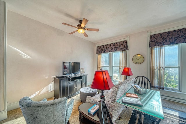 carpeted living room featuring baseboard heating and ceiling fan