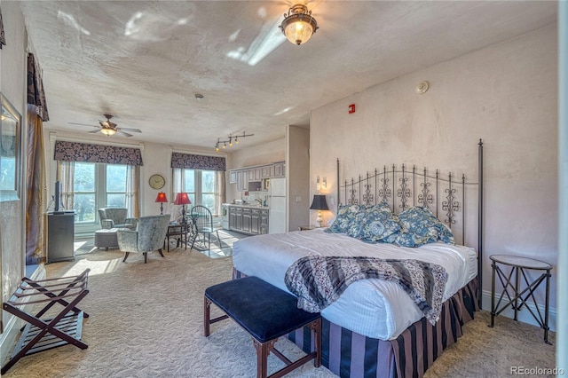 bedroom featuring light carpet, ceiling fan, and white refrigerator