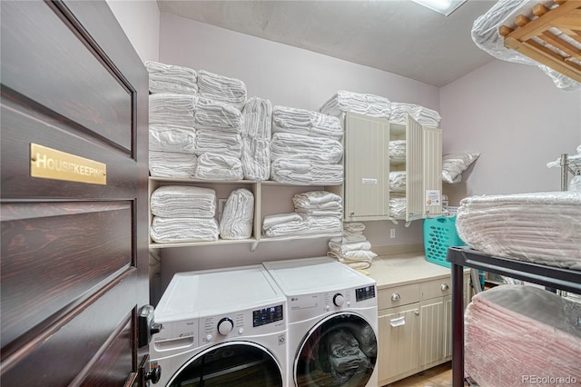 washroom featuring washing machine and dryer and cabinets